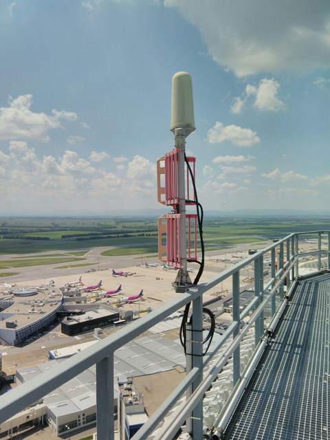 Antennenmontage auf einer Dachplattform mit Blick über ein Flughafengelände